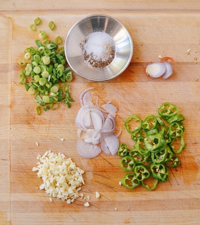 chopped scallions, shallots, garlic, and peppers on cutting board, thewoksoflife.com