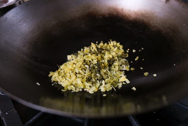 Adding mustard greens to wok, thewoksoflife.com