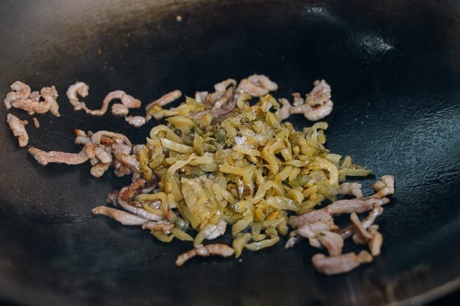 Adding zha cai to pork in wok, thewoksoflife.com