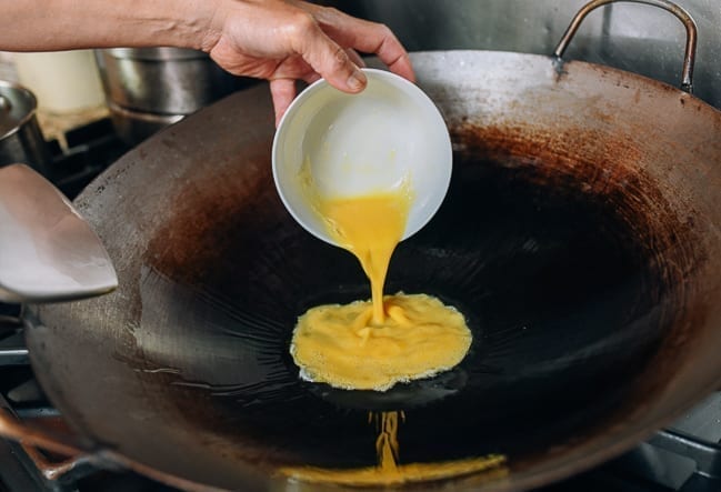 Adding beaten eggs to hot wok, thewoksoflife.com