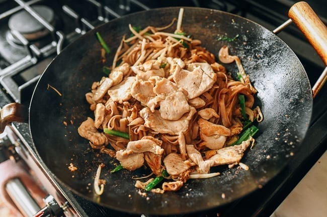 Adding chicken back to wok with noodles, thewoksoflife.com