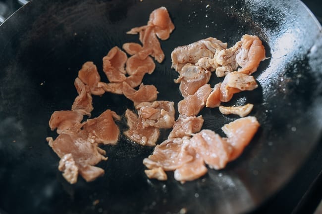 Searing sliced chicken in wok, thewoksoflife.com