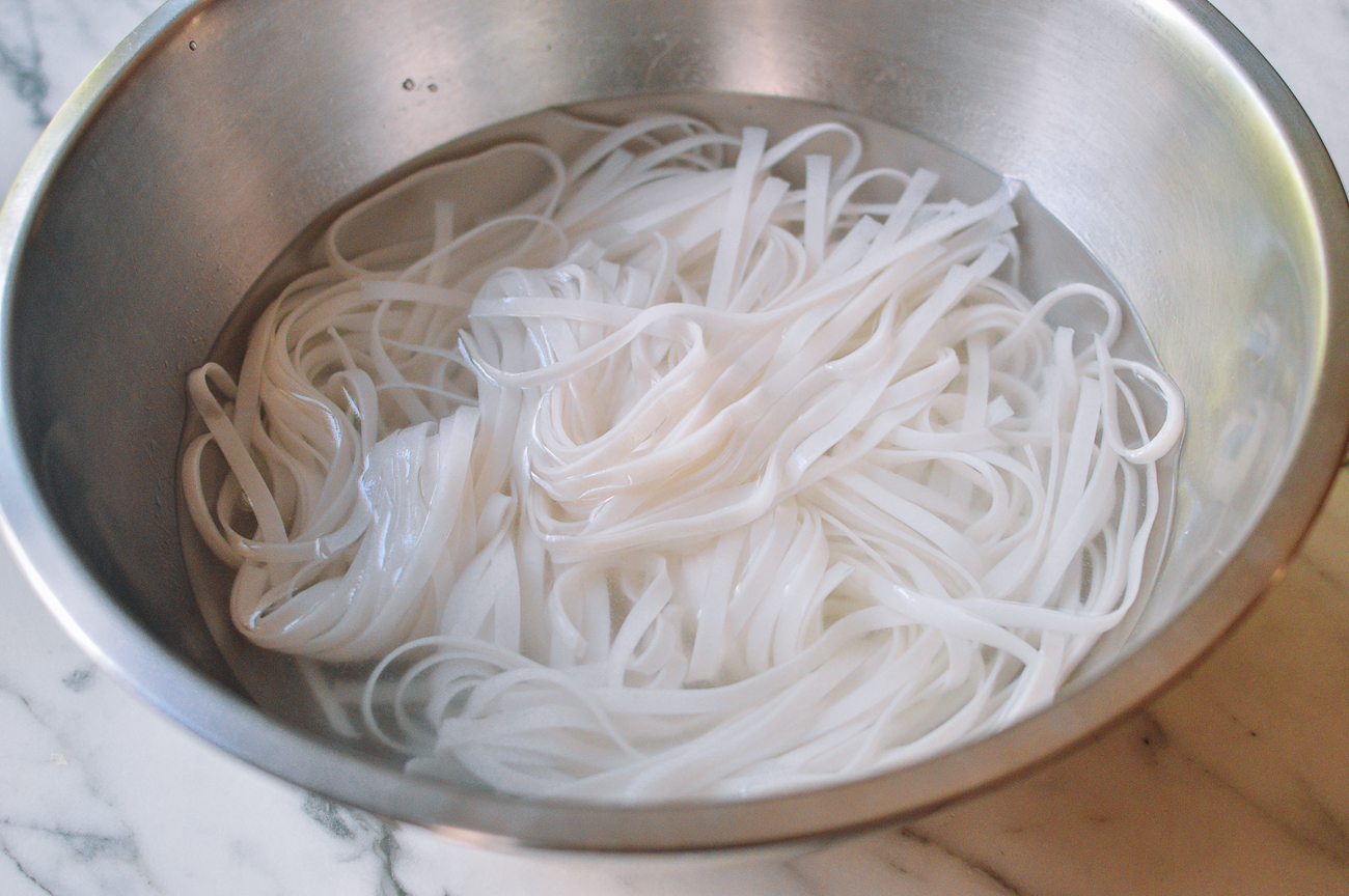 soaking pad thai noodles in metal bowl