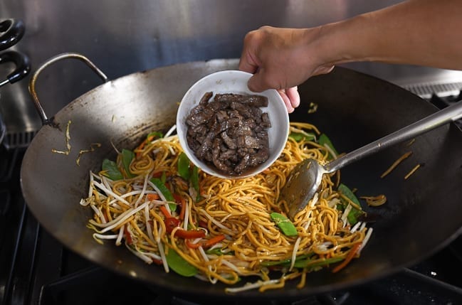 Adding cooked beef back to lo mein in wok, thewoksoflife.com