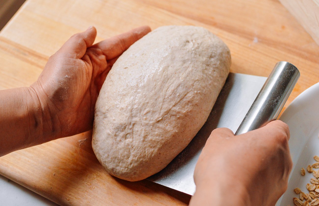 shaping bread dough into a loaf