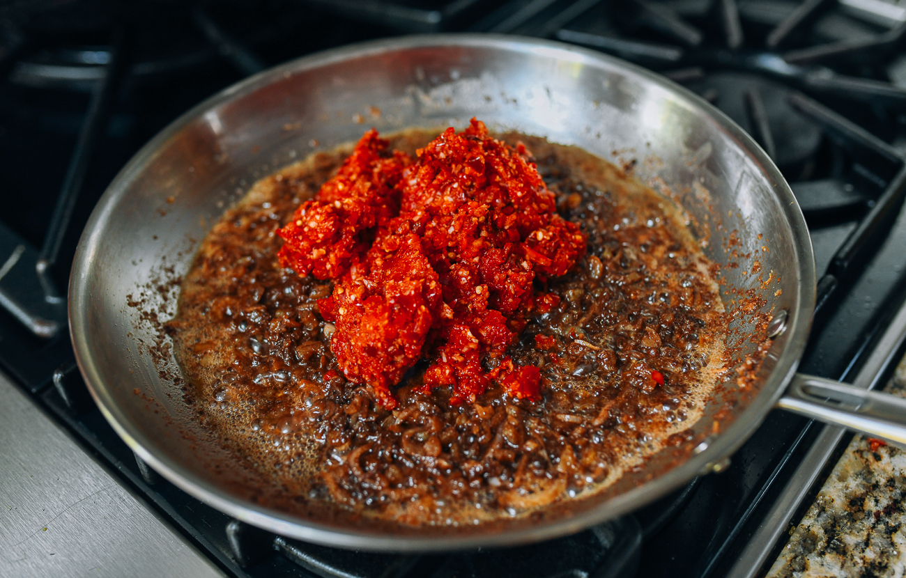 Adding chili, shallot and garlic paste to shrimp mixture