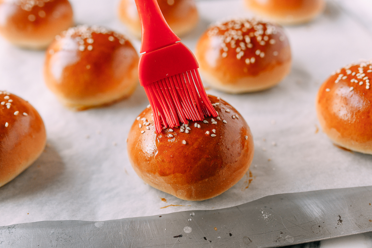 Brushing baked buns with sugar syrup