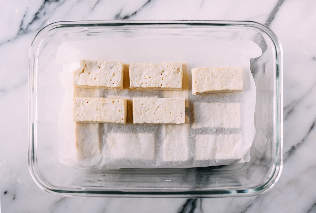 Tofu in container with parchment paper