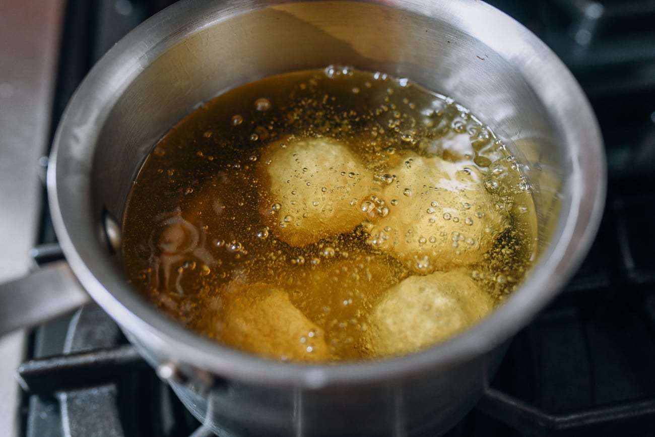 Adding sesame balls to frying oil