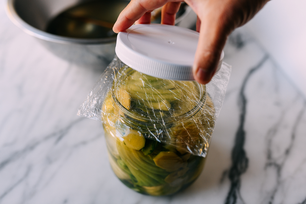 Placing lid on jar with plastic wrap in between