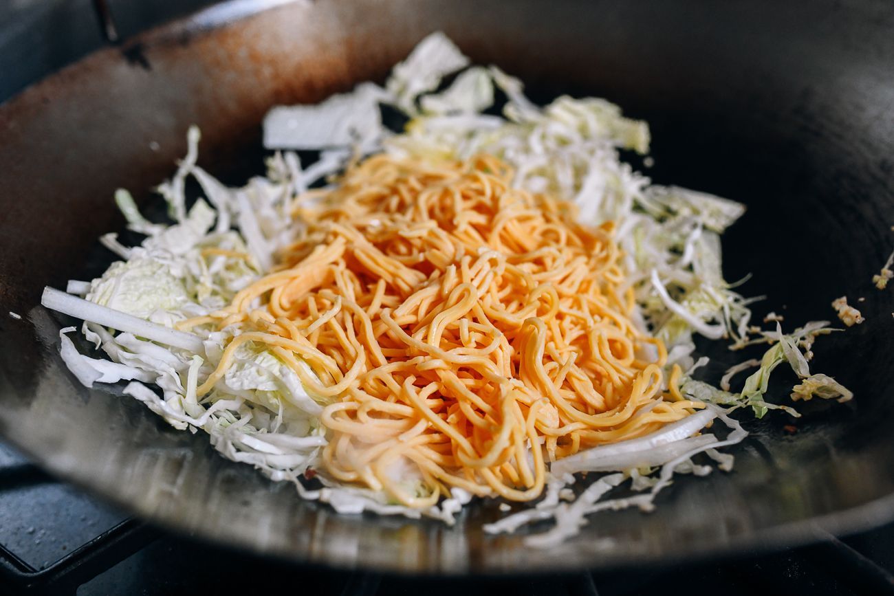 Adding hokkien mee yellow noodles to wok
