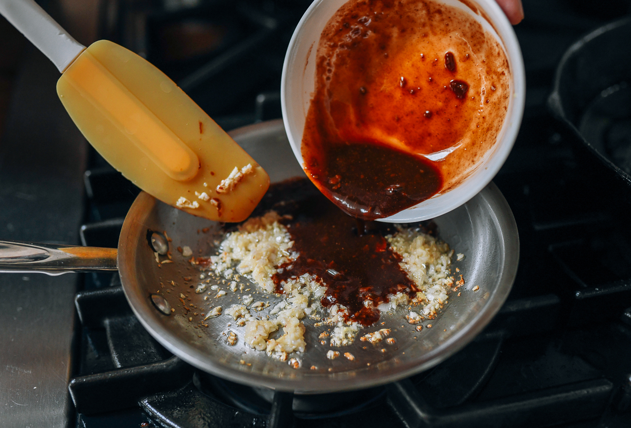 Adding sauce mixture to ginger, garlic, and shallots
