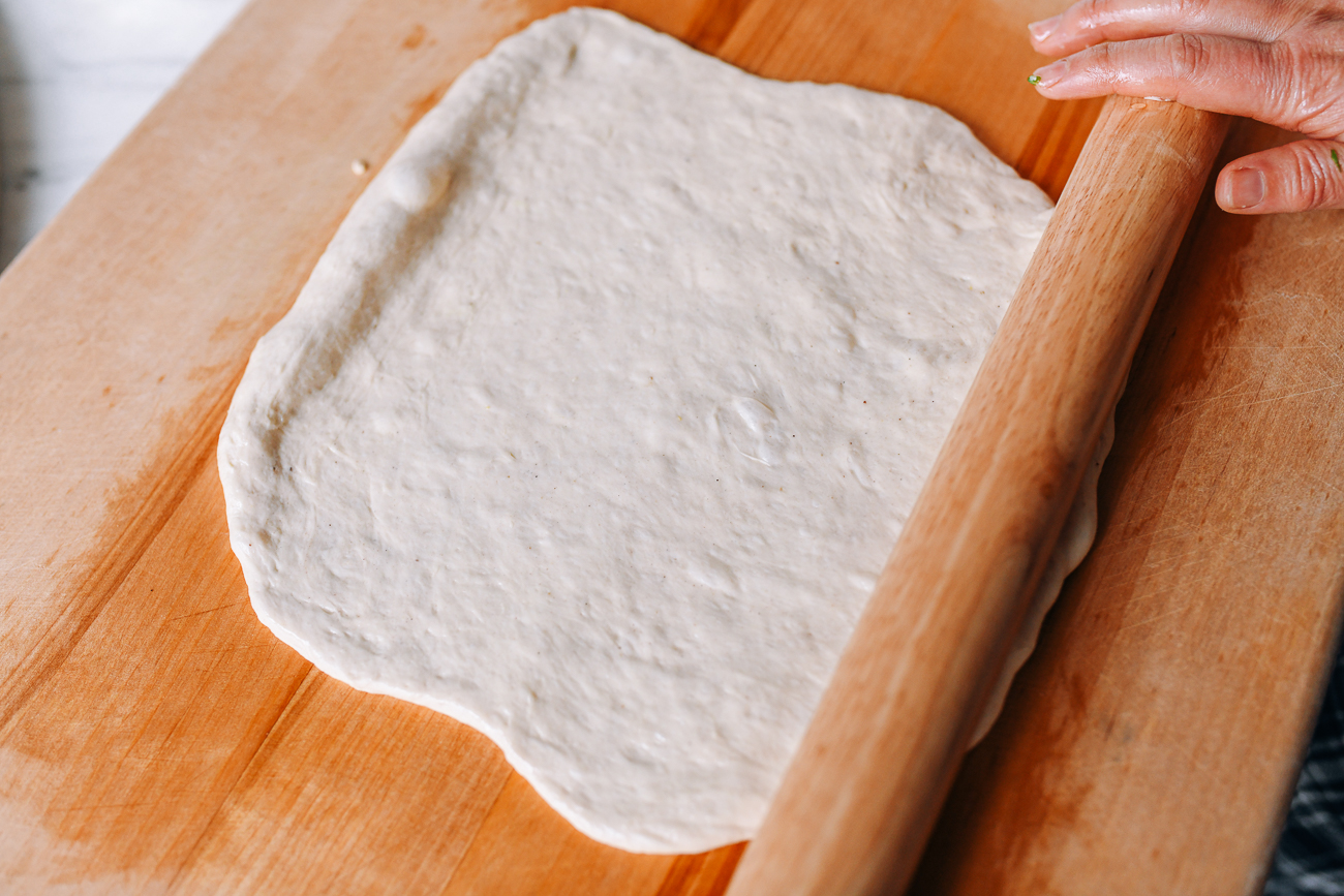 Rolling dough into flat rectangle with an oiled rolling pin