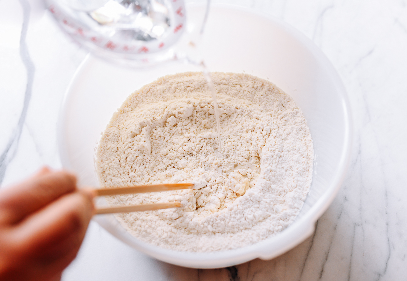 Stirring water into flour, yeast, and sugar mixture