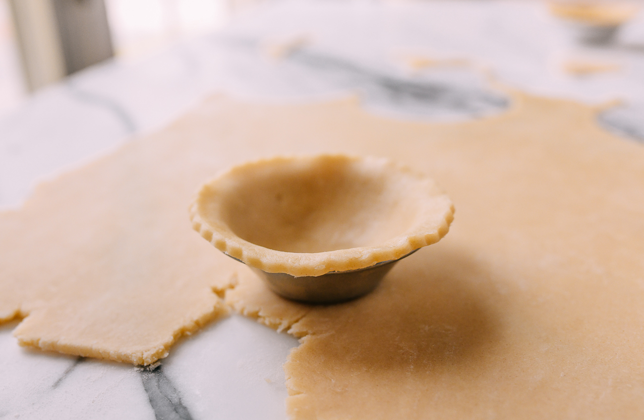 Pastry dough pressed into a mini tart tin