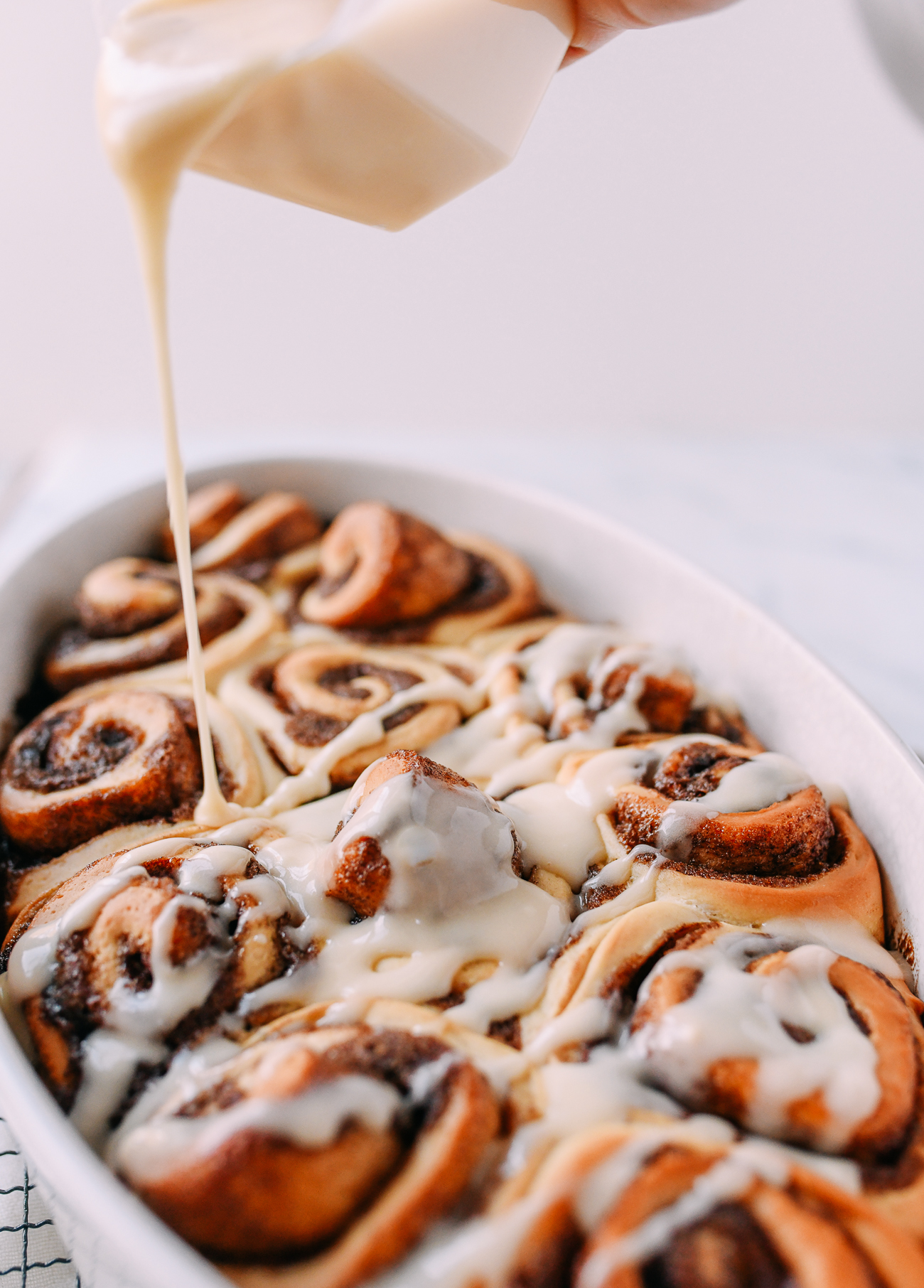Drizzling cinnamon rolls with icing