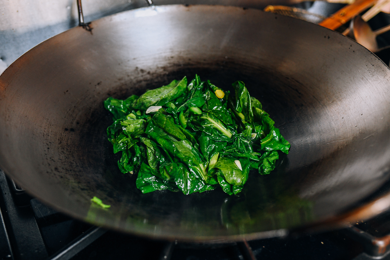 Piling Chinese broccoli in center of wok