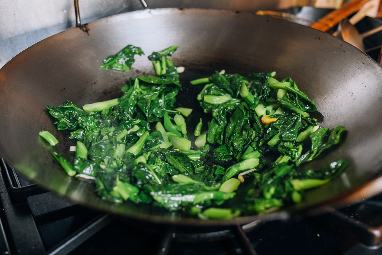 Spreading greens around superheated sides of wok