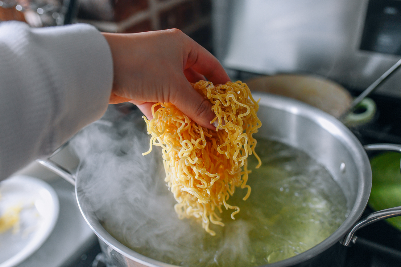 Adding ramen noodles to pot of boiling water