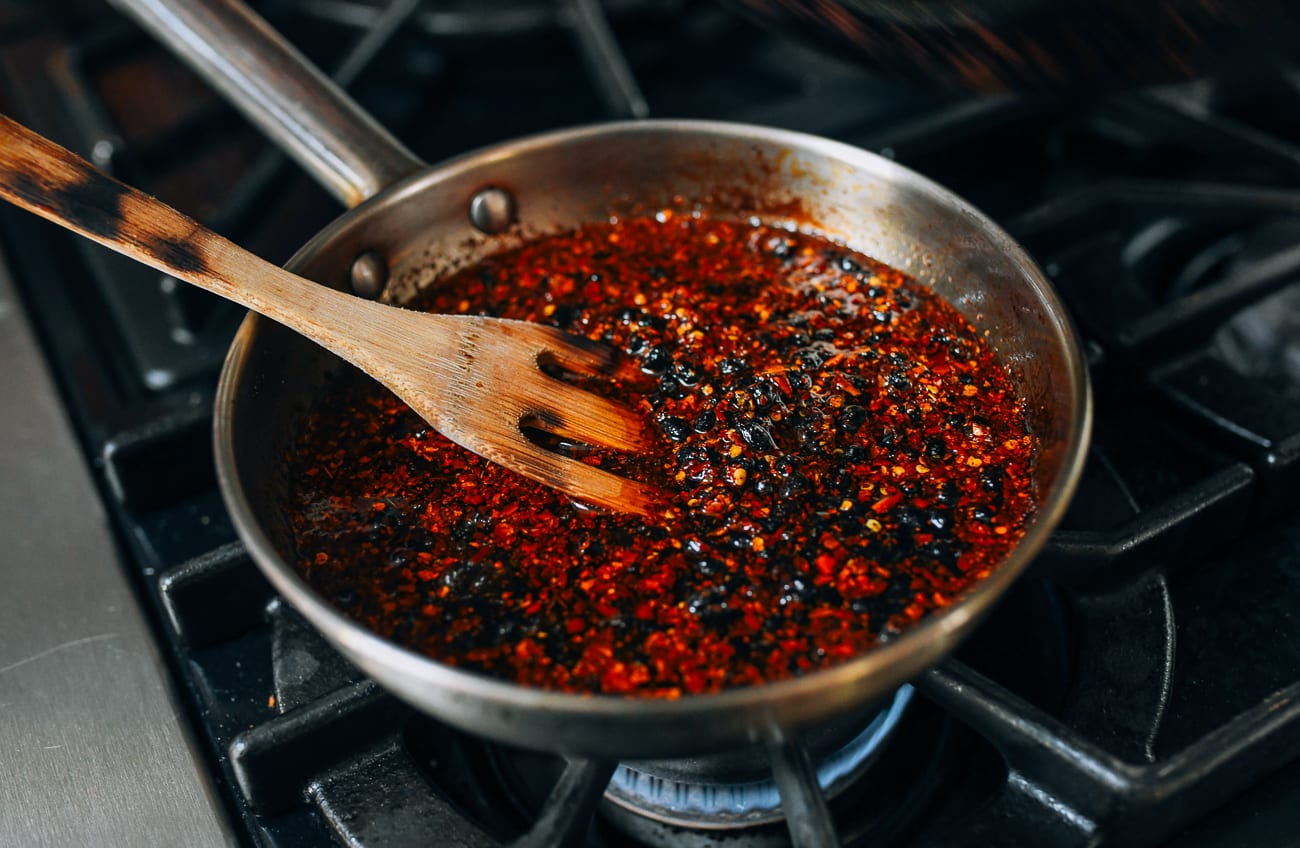 Stirring chili flakes with oil and black beans