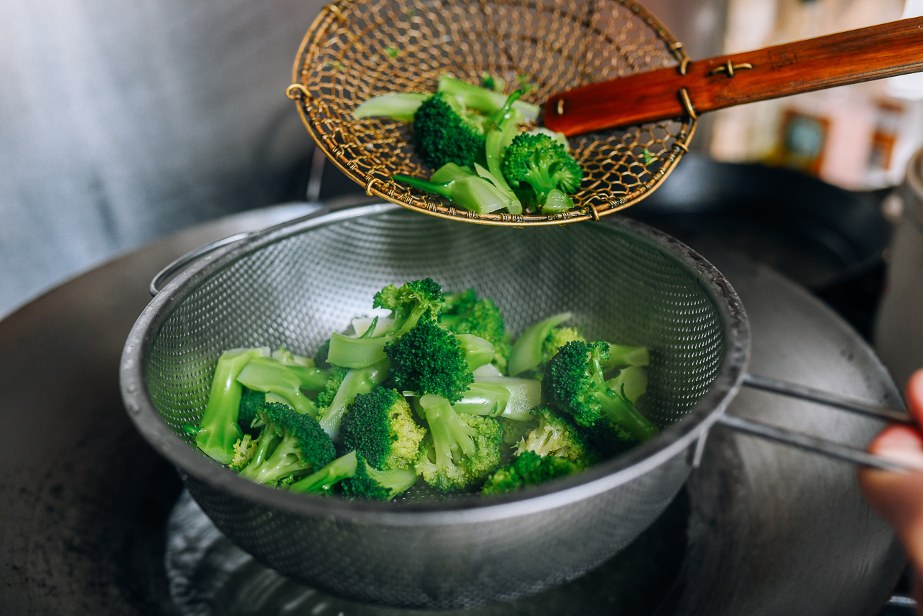 Removing blanched broccoli to a colander
