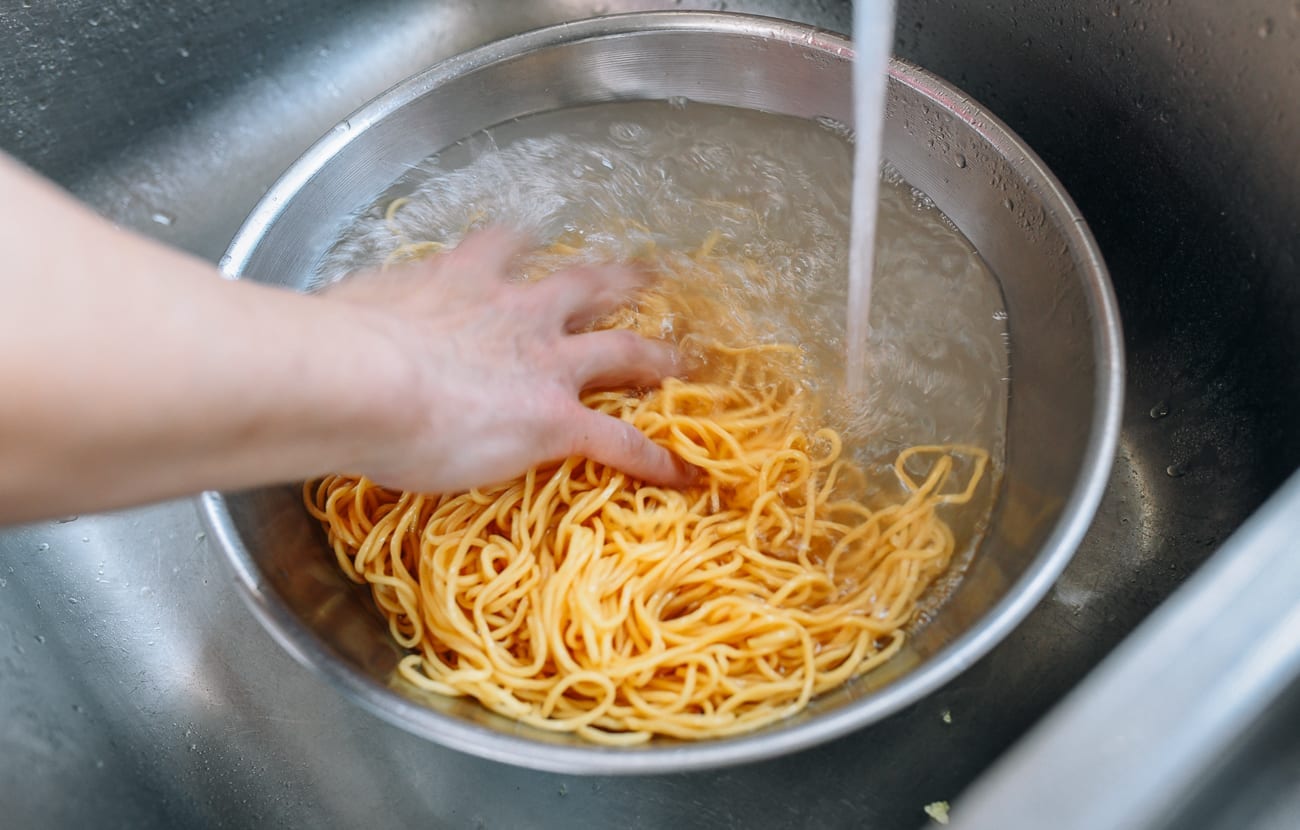 Rinsing cooked lo mein noodles in cold water