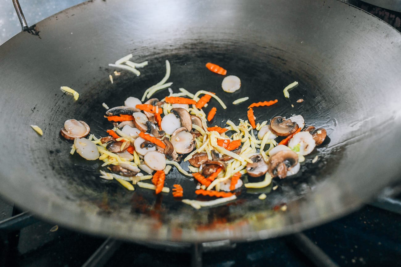 Stir-frying water chestnuts, bamboo shoots, carrots, and mushrooms