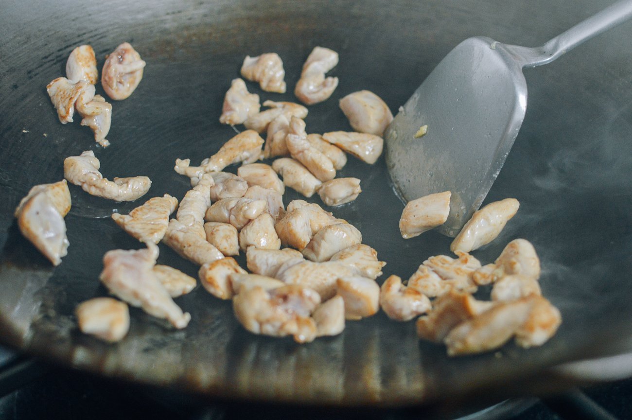 Seared chicken pieces in wok