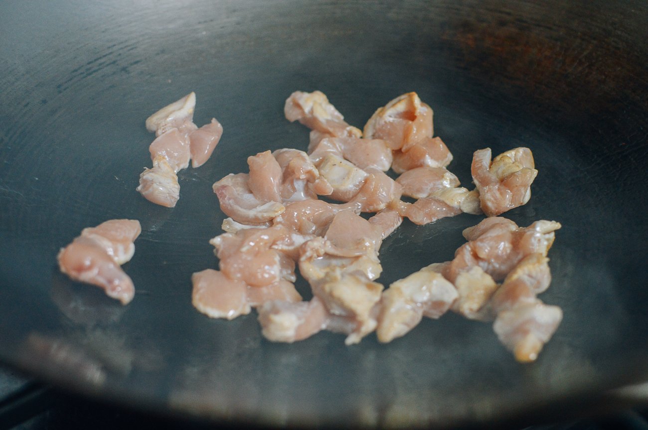 cubes of chicken searing in wok