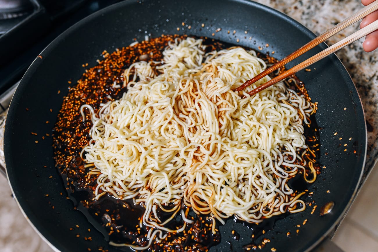 adding noodles to sauce
