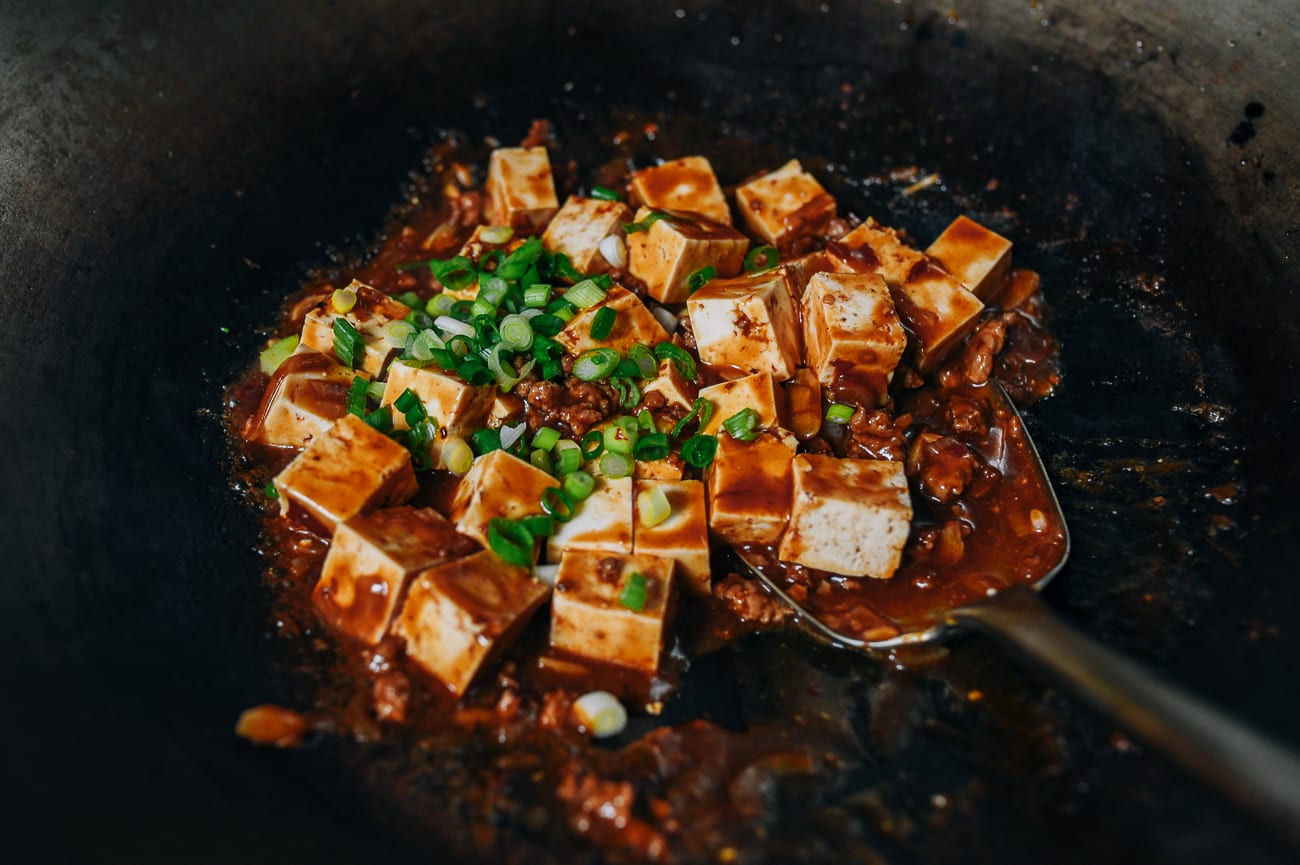 Stirring scallions into tofu cubes