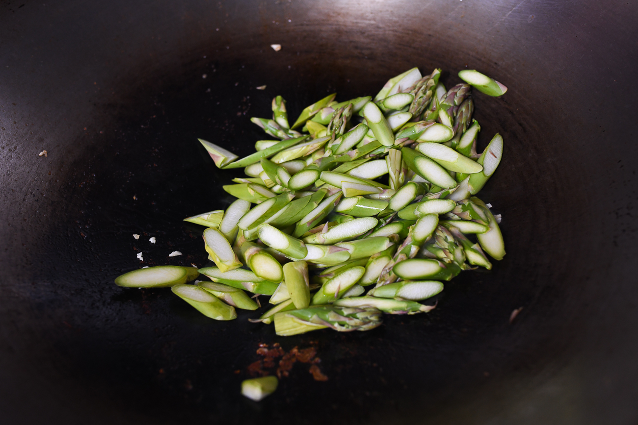 Sliced asparagus on wok