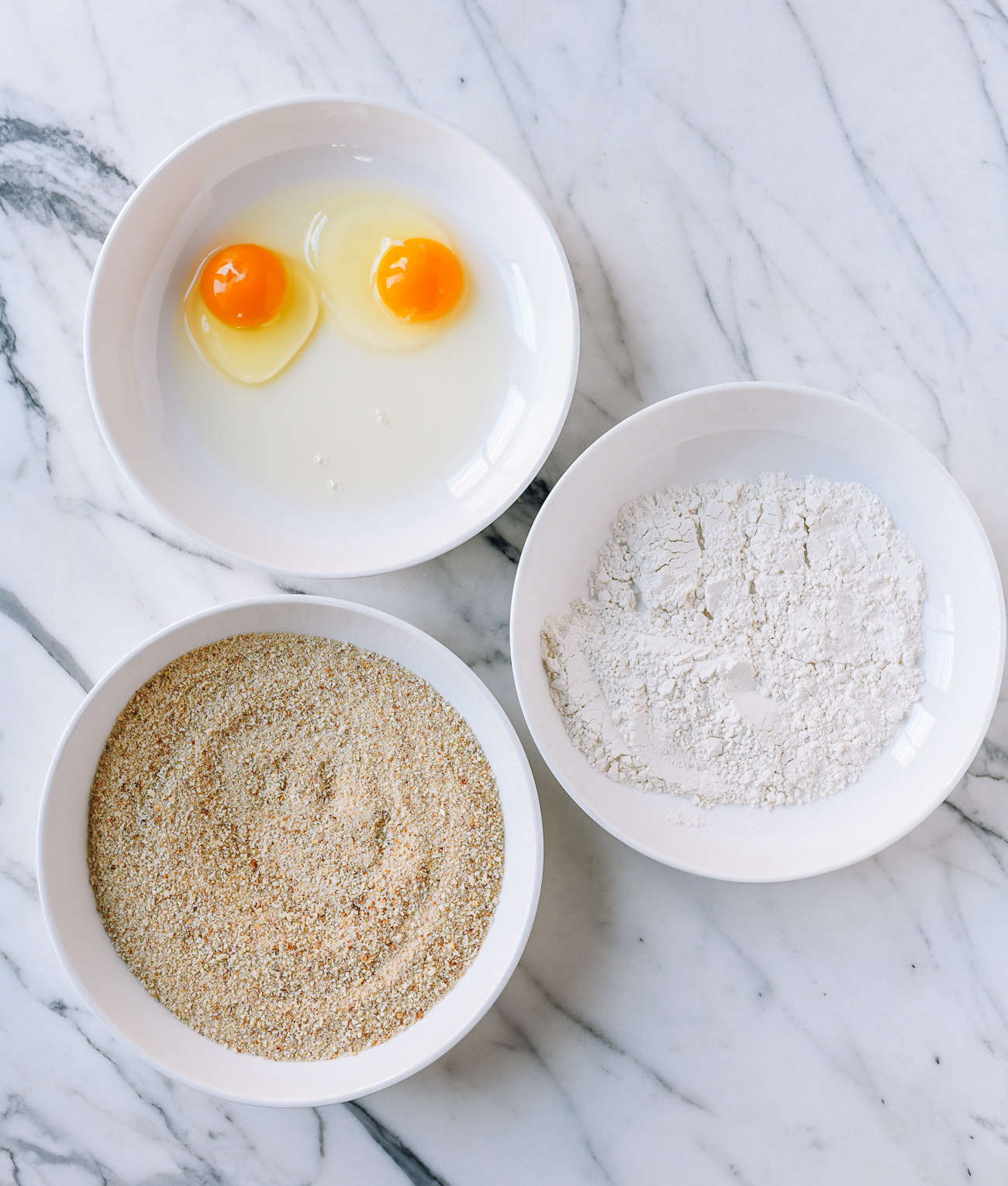 Dishes with egg, flour, and breadcrumbs for dredging