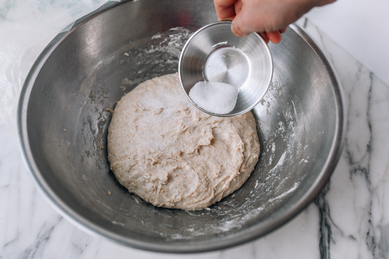 Sprinkling salt over bread dough