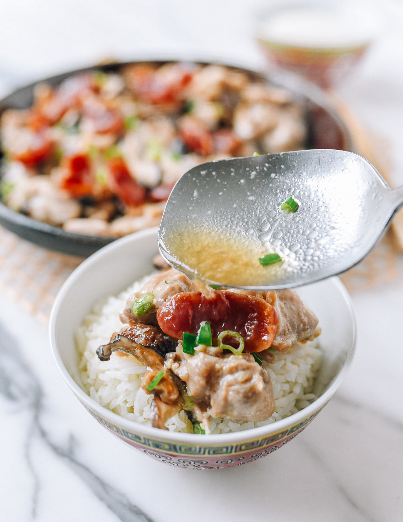 Pouring sauce from steamed chicken over rice