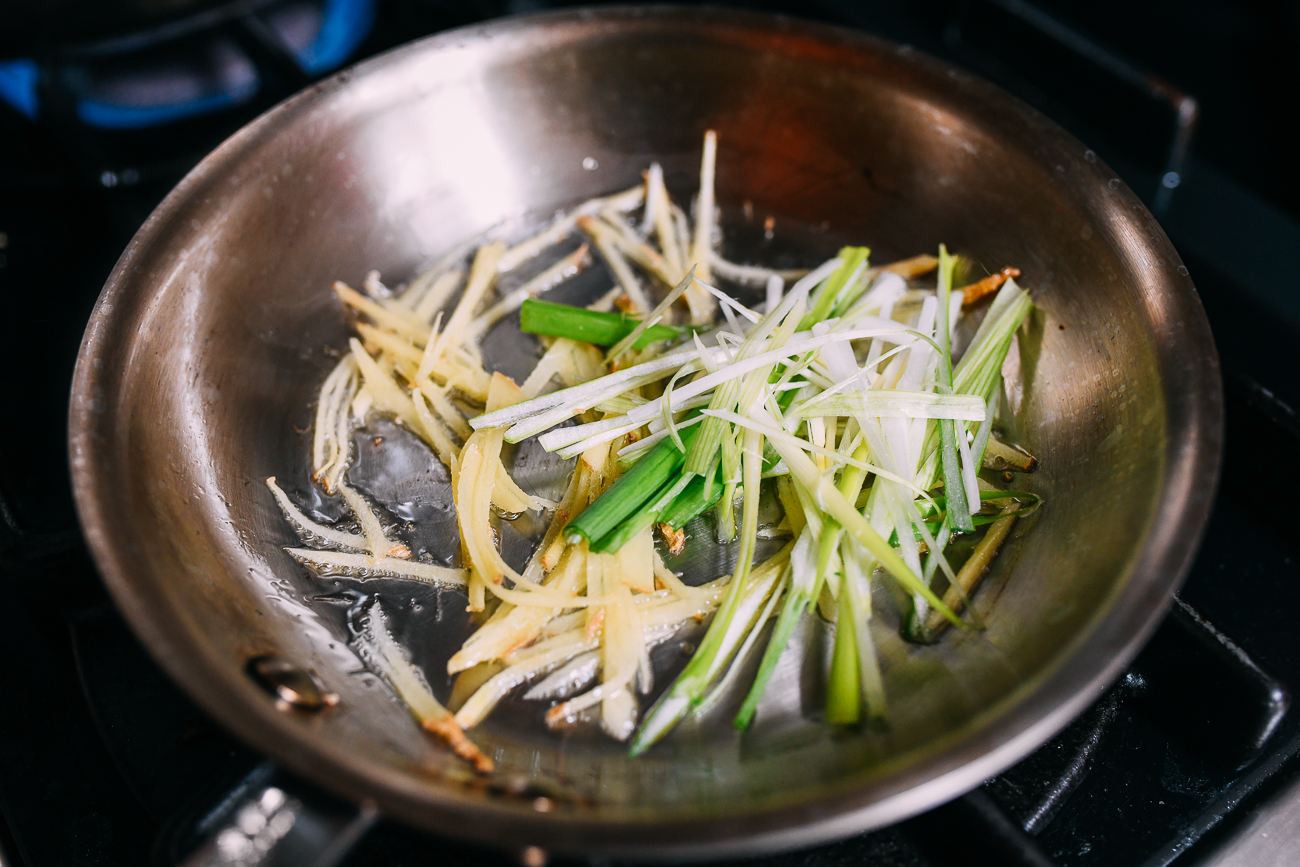 Adding white parts of scallions to ginger
