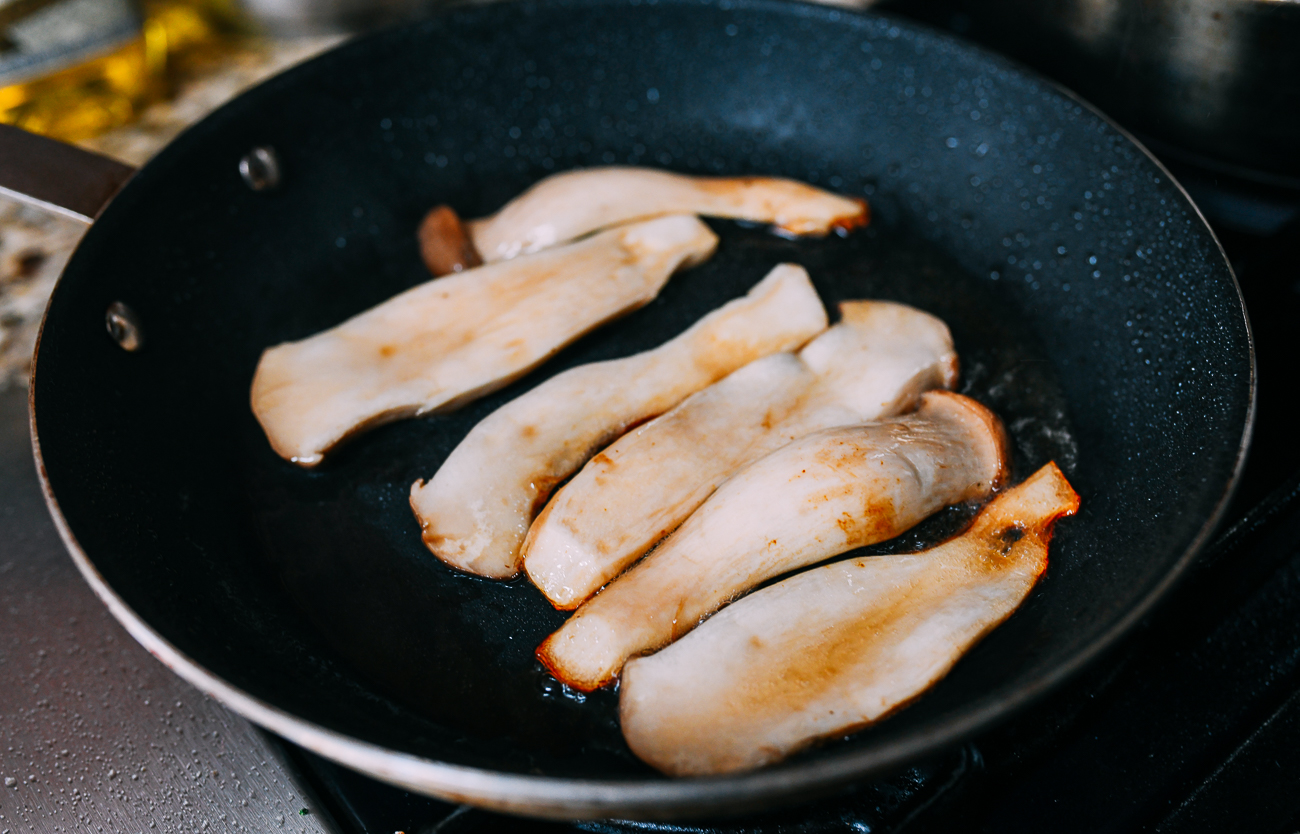 Frying sliced king oyster mushrooms in nonstick pan