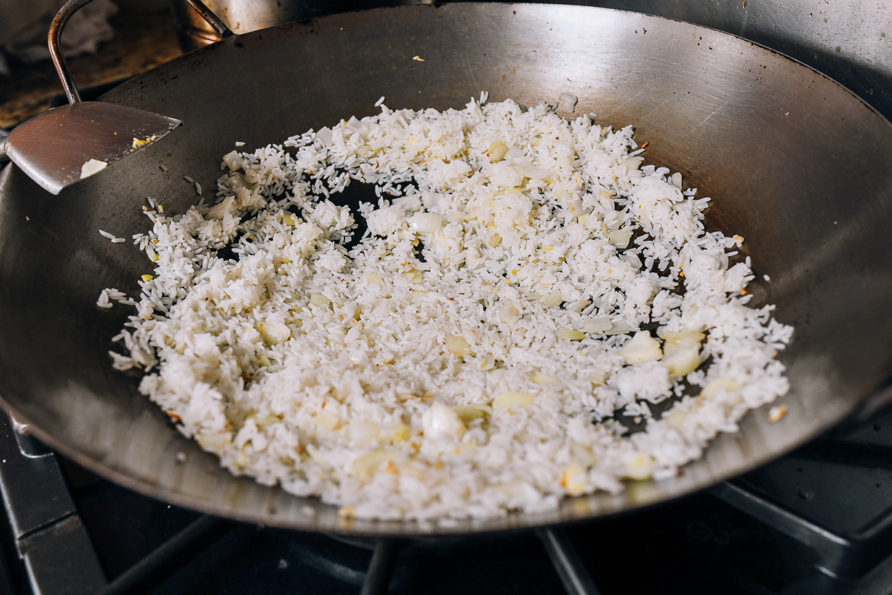Spreading rice out in a single layer in wok