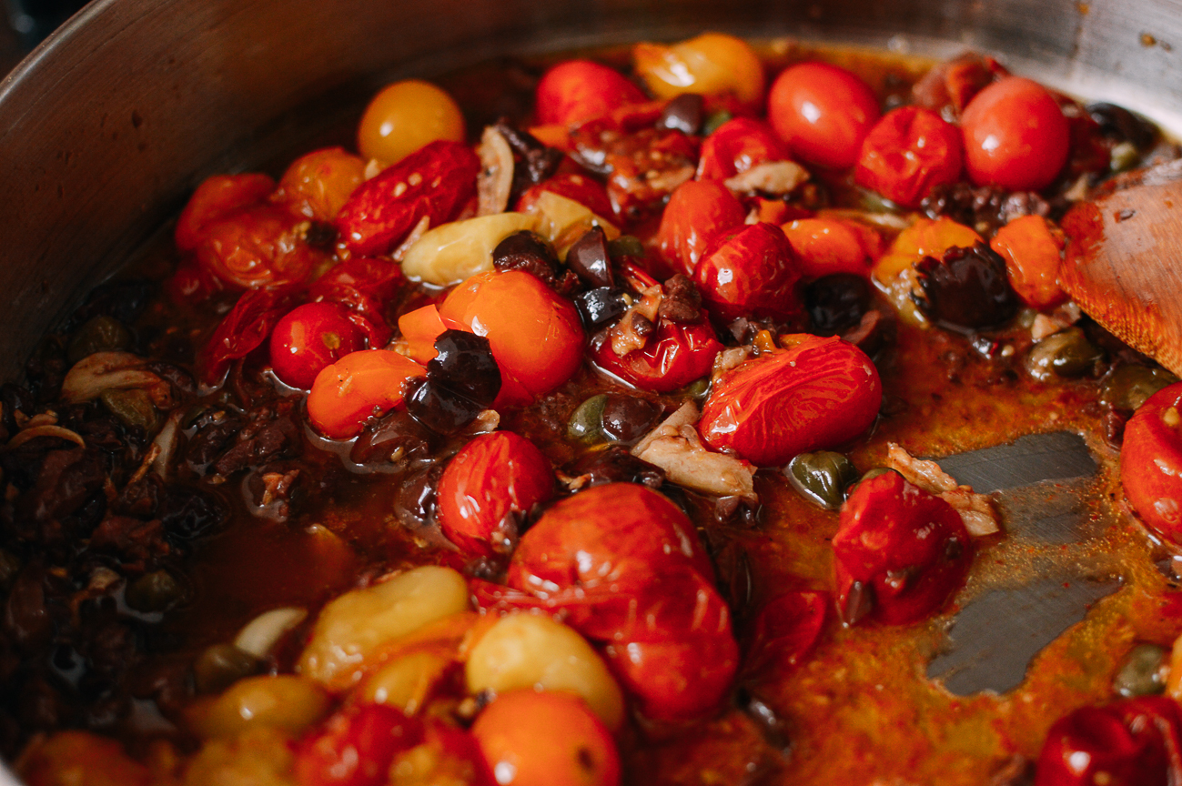 Adding roasted cherry tomatoes to pan