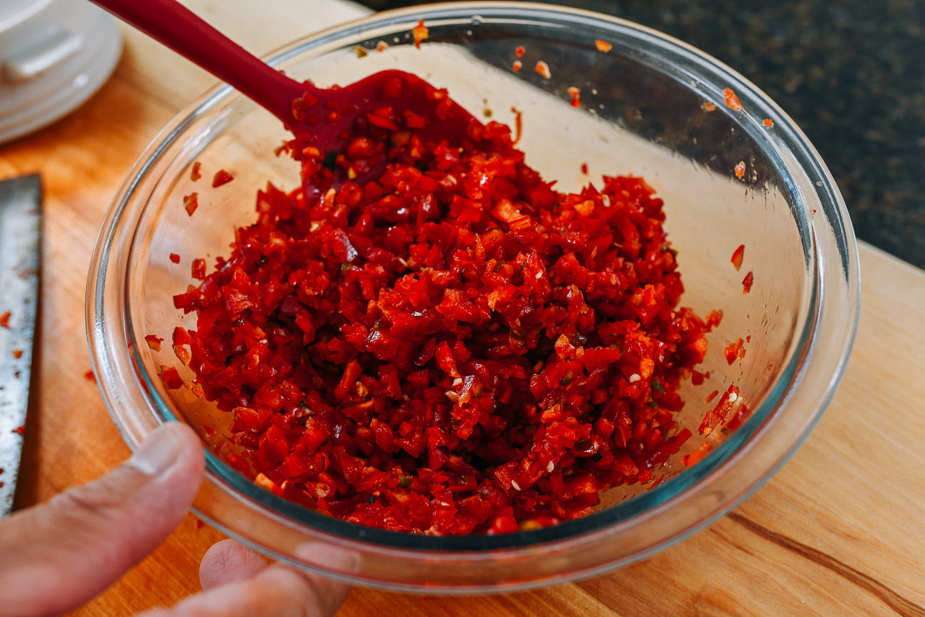 Mixing chopped chilies with salt, sugar, and rice wine