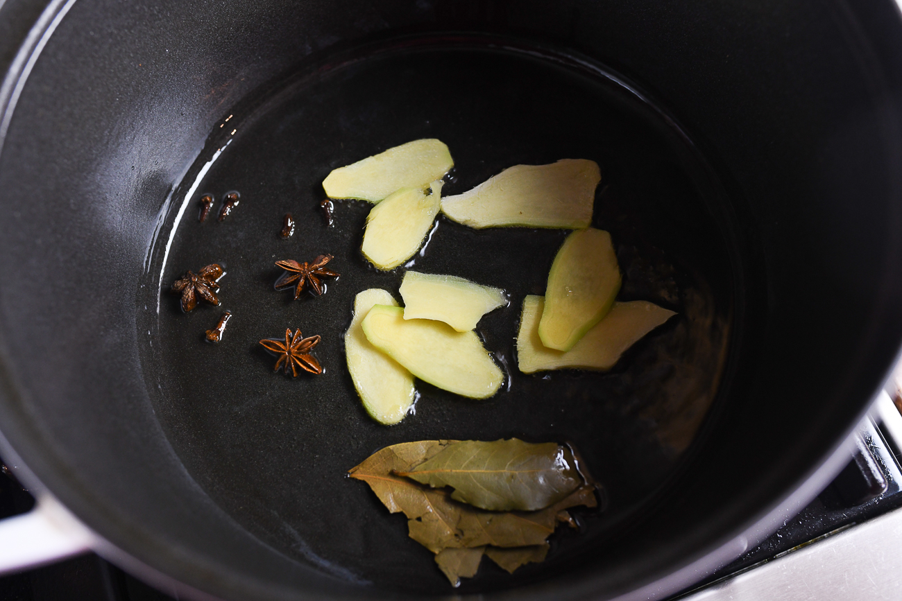 star anise, cloves, ginger and bay leaves in Dutch oven