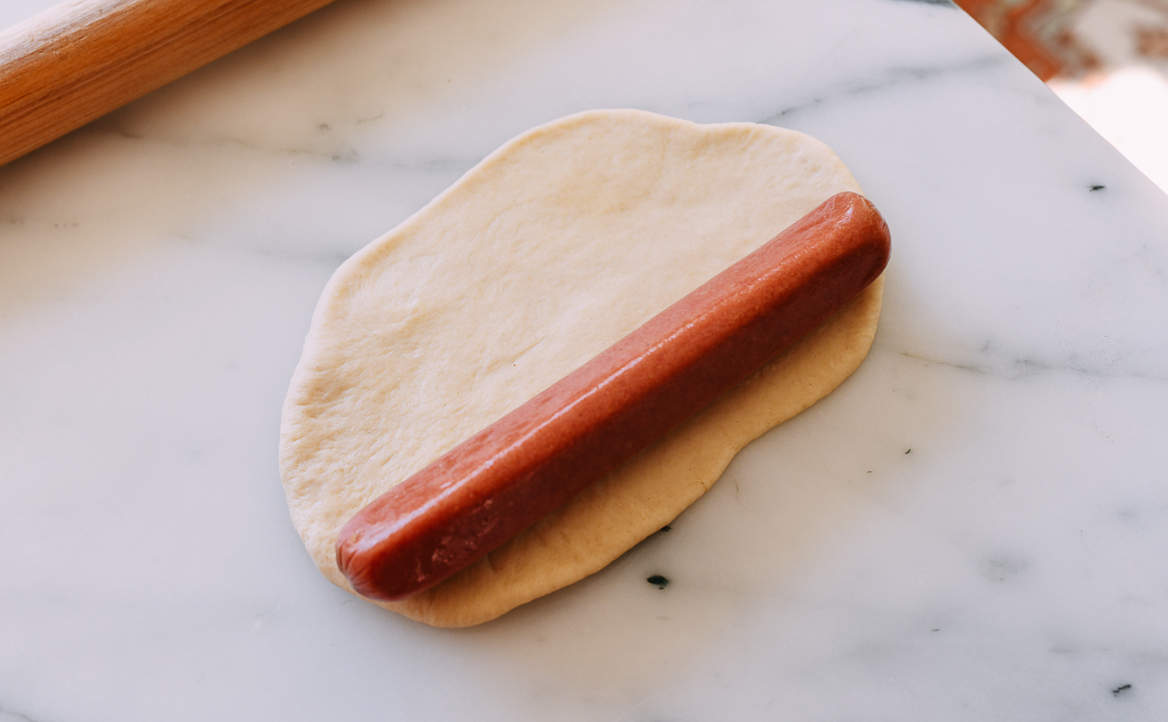 Hot dog on rolled out oval of dough