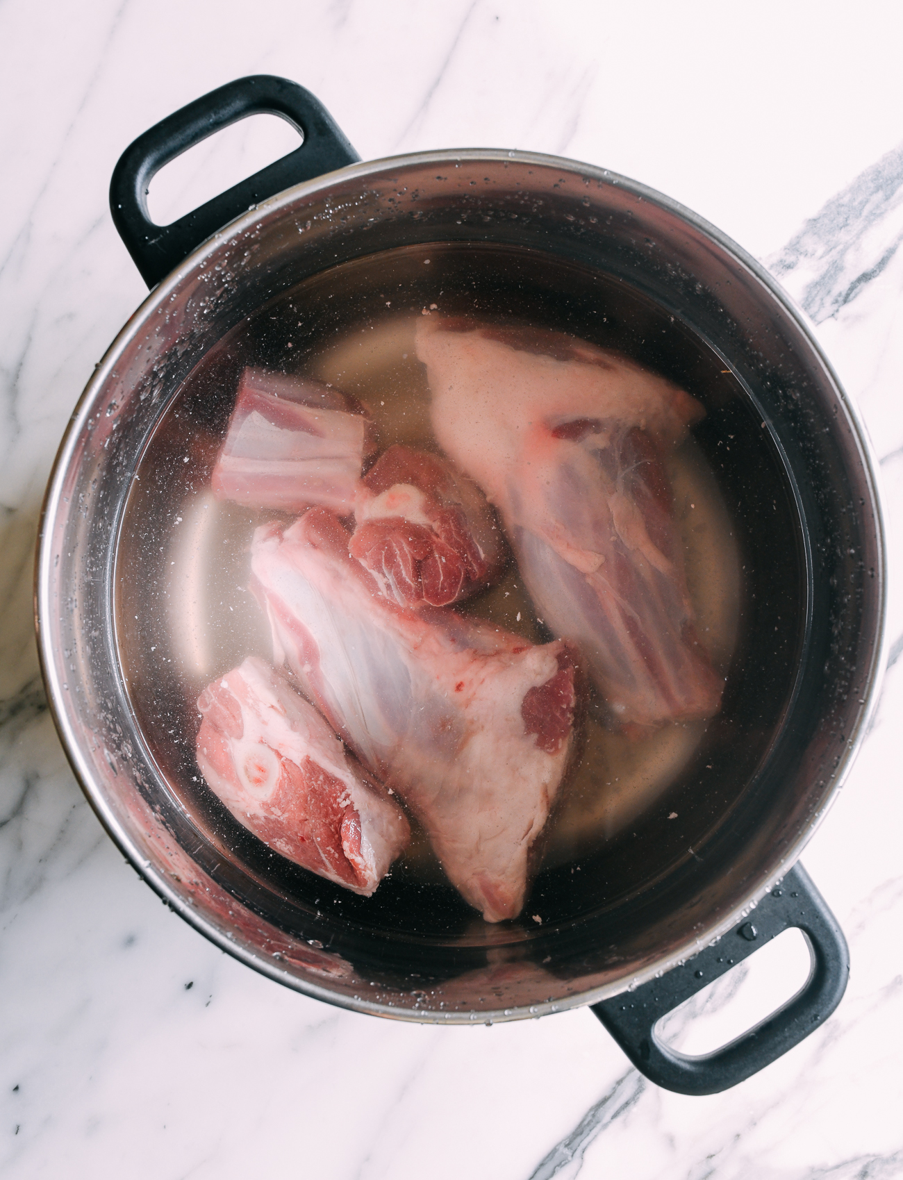 Soaking lamb bones in pot of cold water