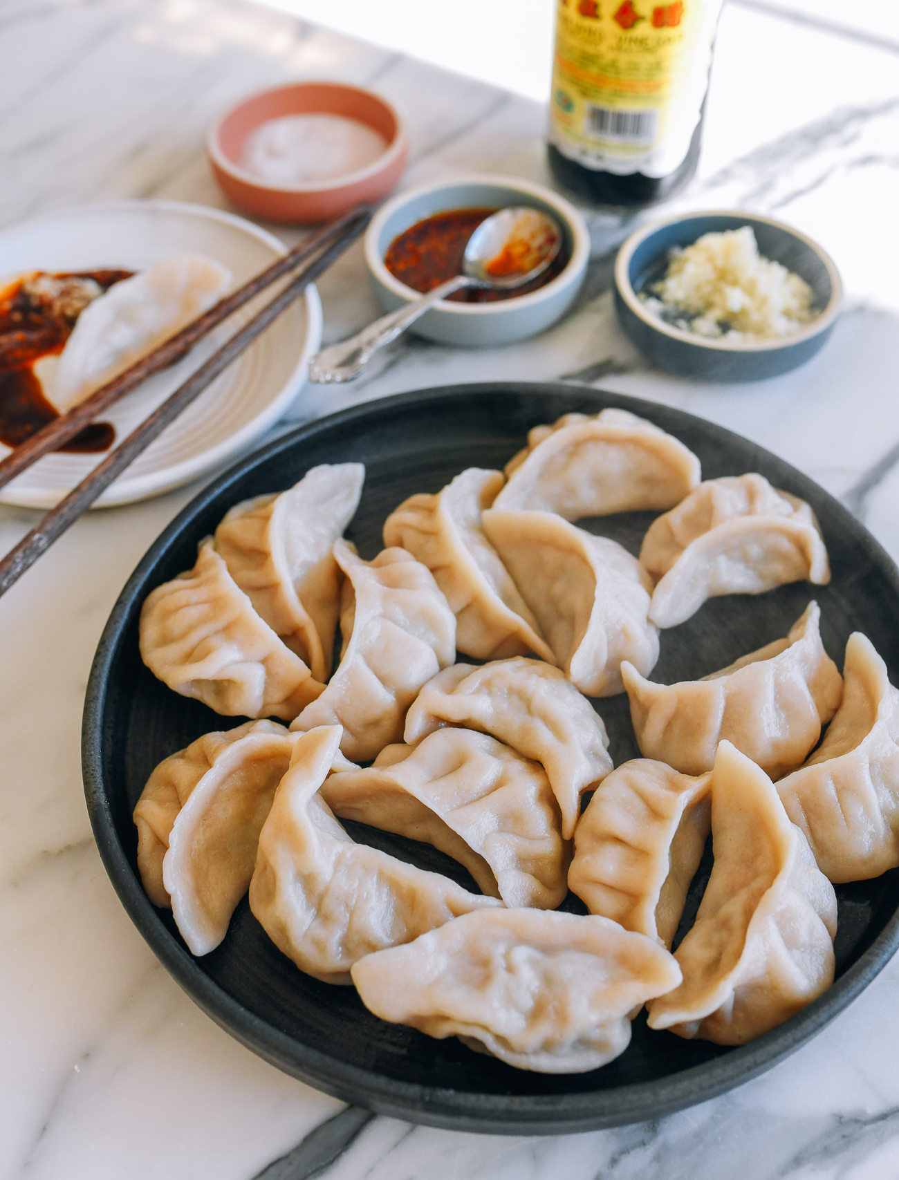 Plate of boiled dumplings with condiments