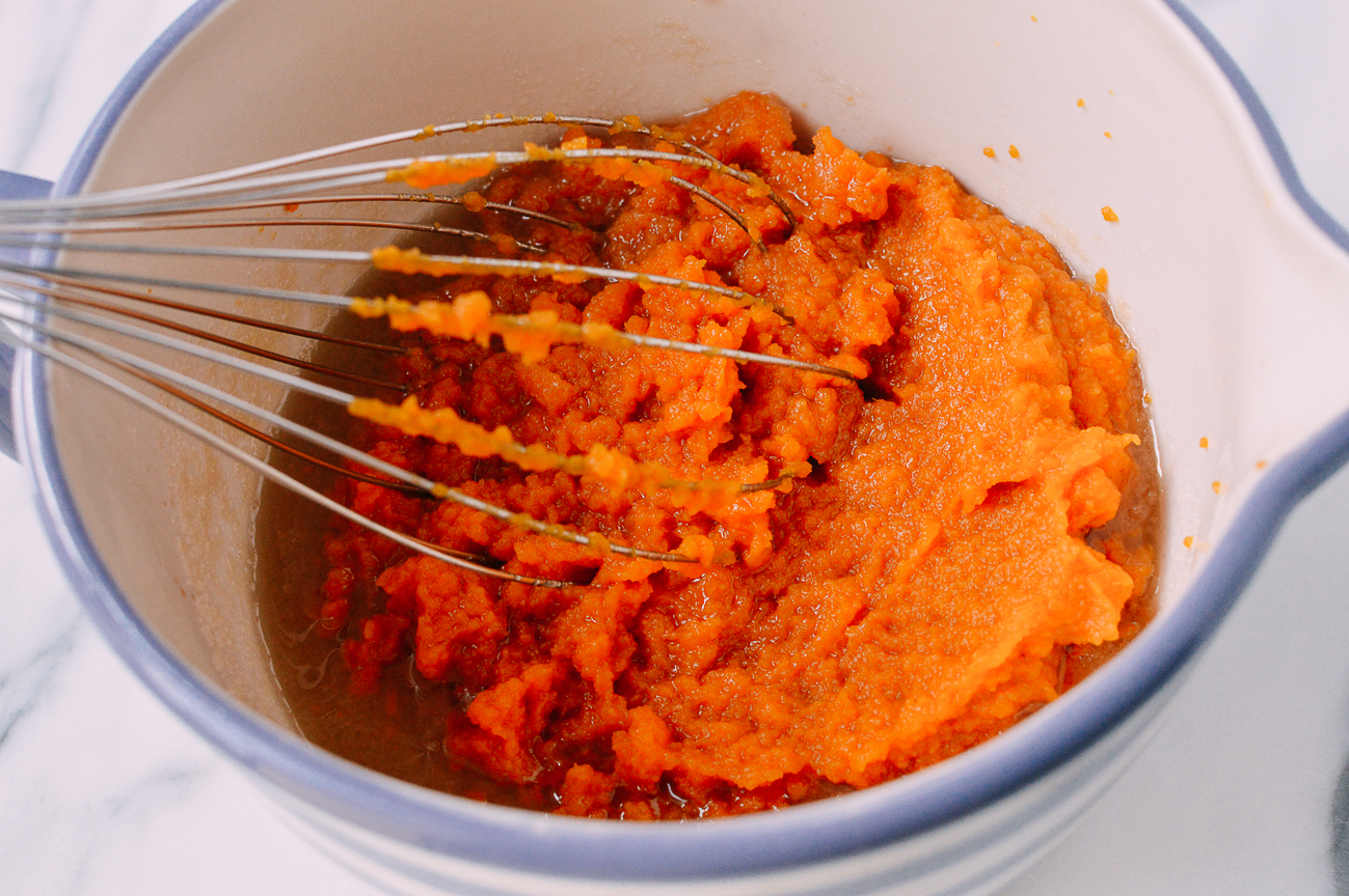 Canned pumpkin in mixing bowl with whisk