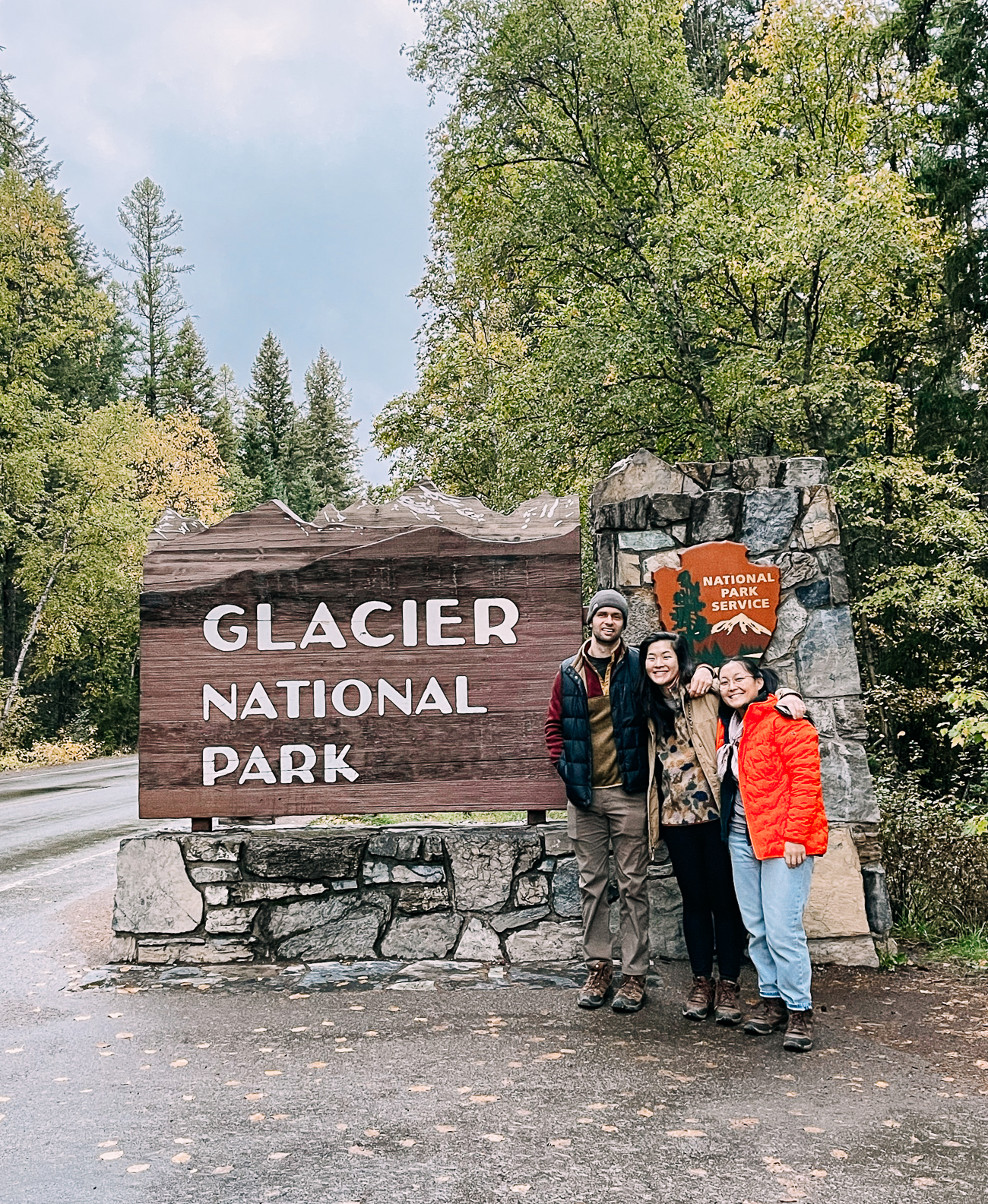 Sarah, Kaitlin, and Justin posing in front of Glacier National Park sign