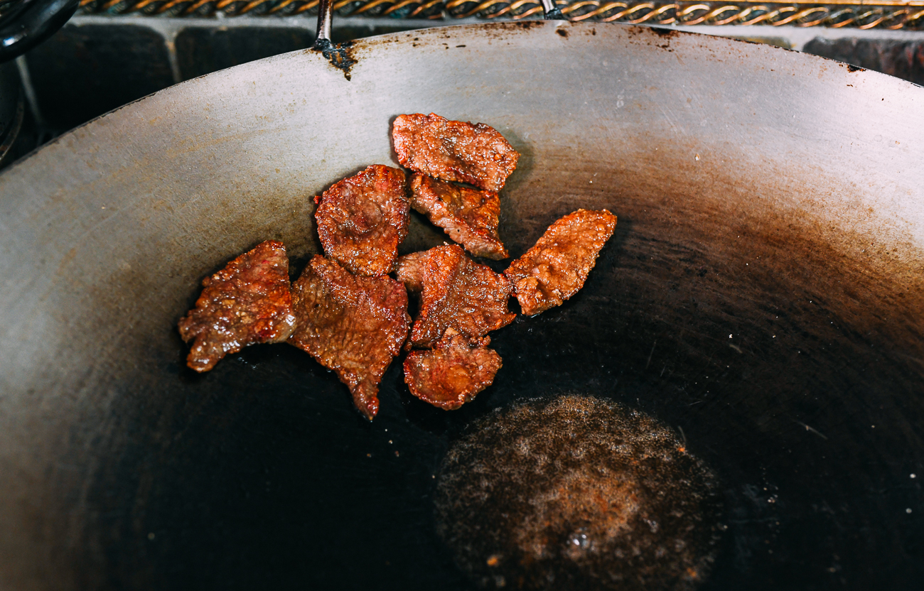 Fried beef draining on side of wok