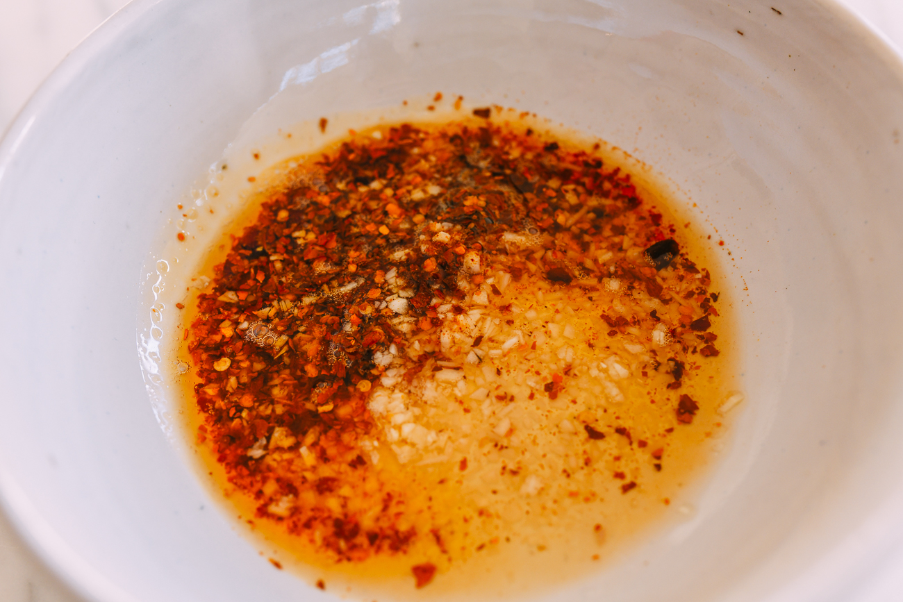 Hot oil added to garlic and Sichuan chili flakes