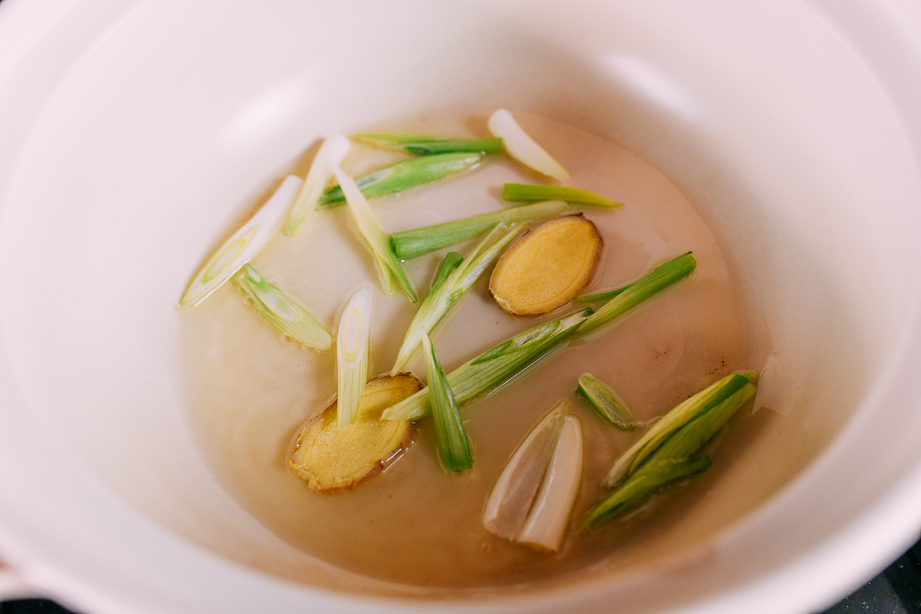 Cooking scallion whites and ginger slices in pot
