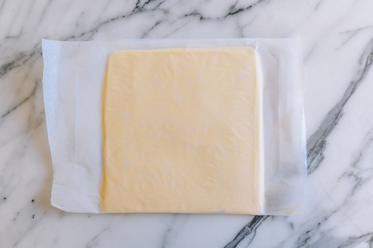 Butter square between parchment paper
